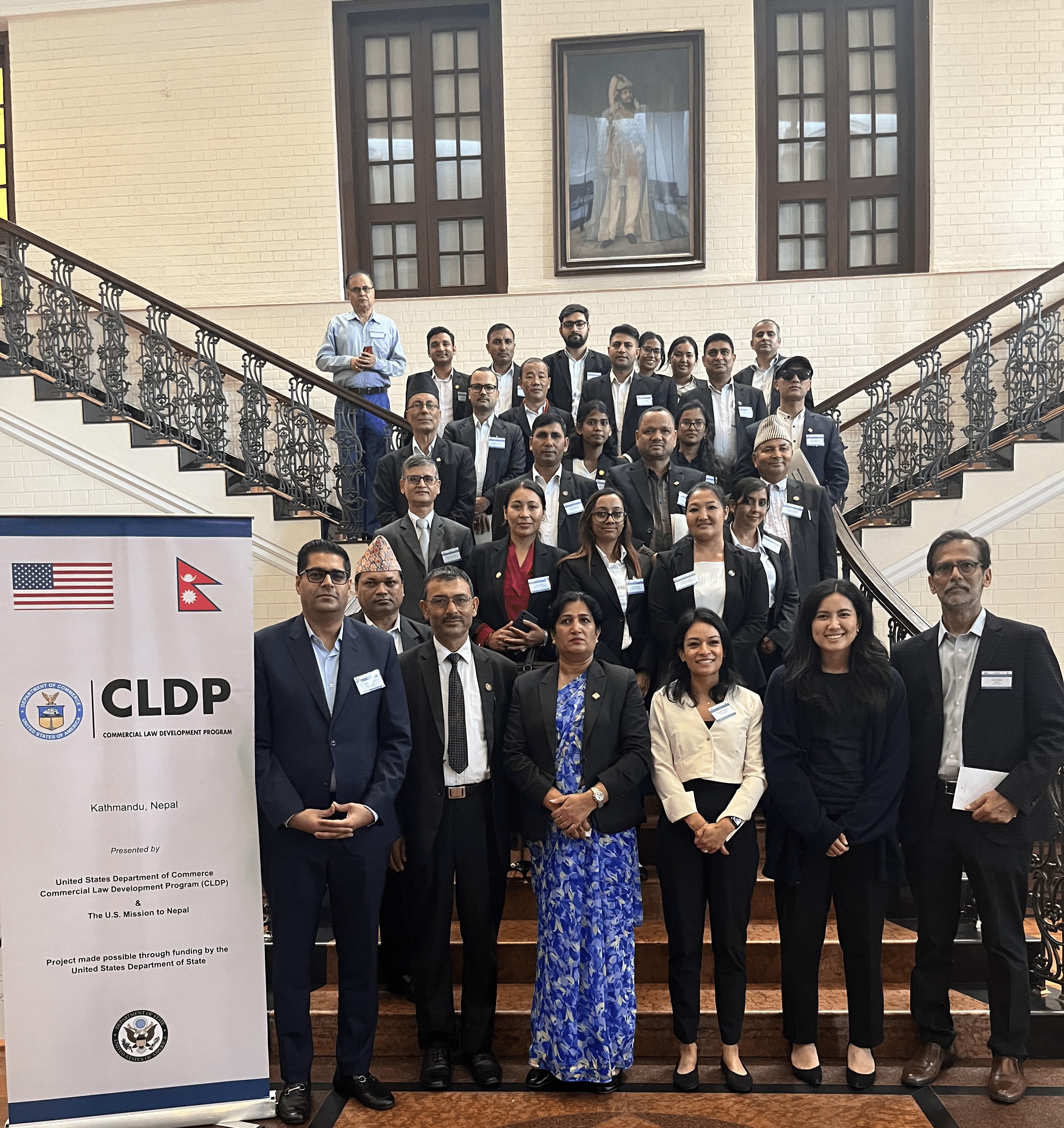 This is a group photo of participants of consultations, there are around 28 participants in a hotel staircase.