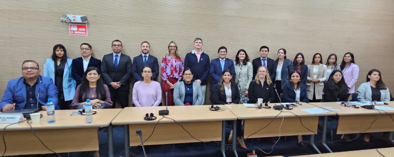 Group of people standing and smiling in two rows.