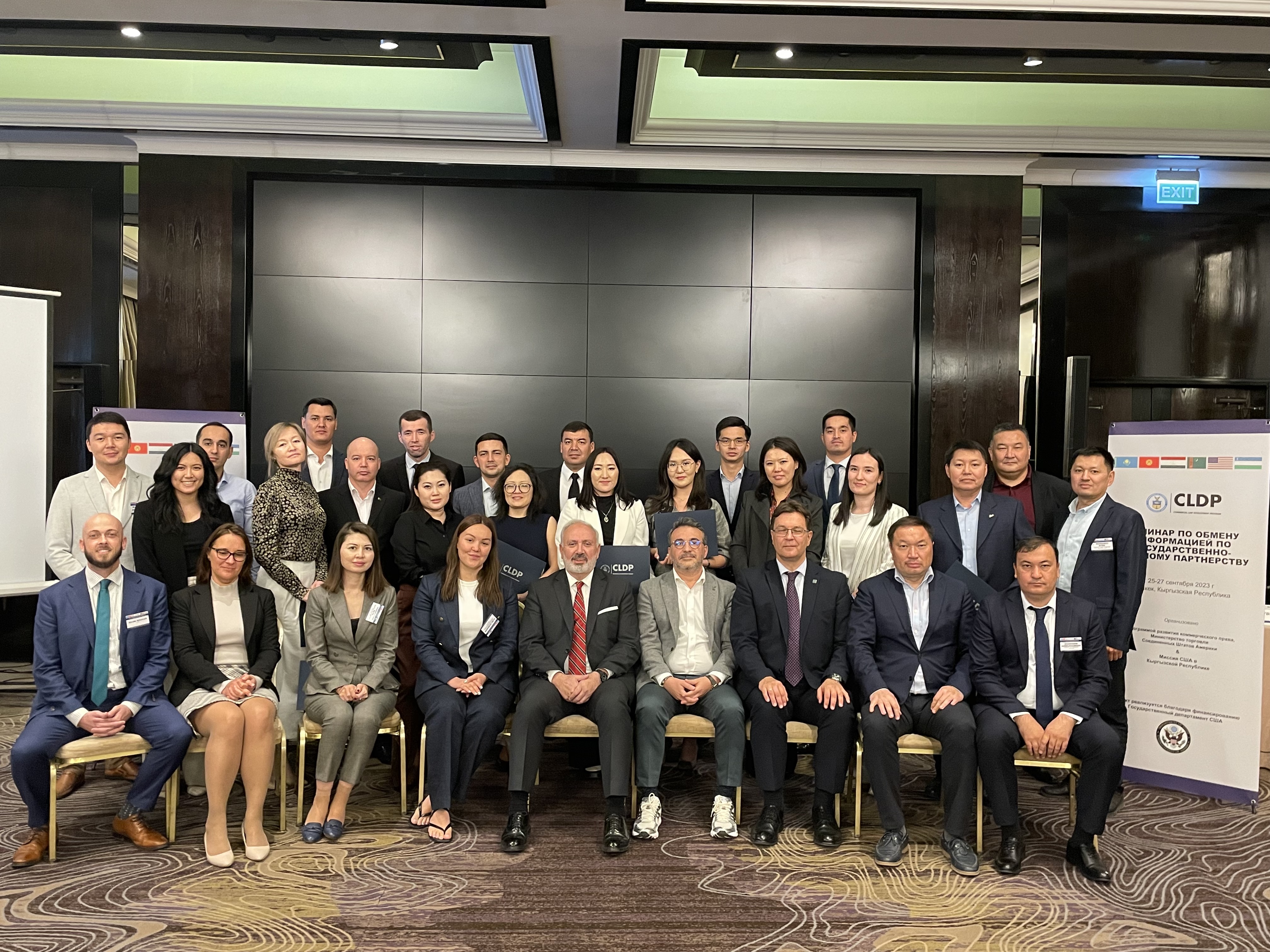 Group photo of participants of the Central Asia Regional PPP Information Exchange Workshop. On the right hand side is a banner with the title of the workshop.