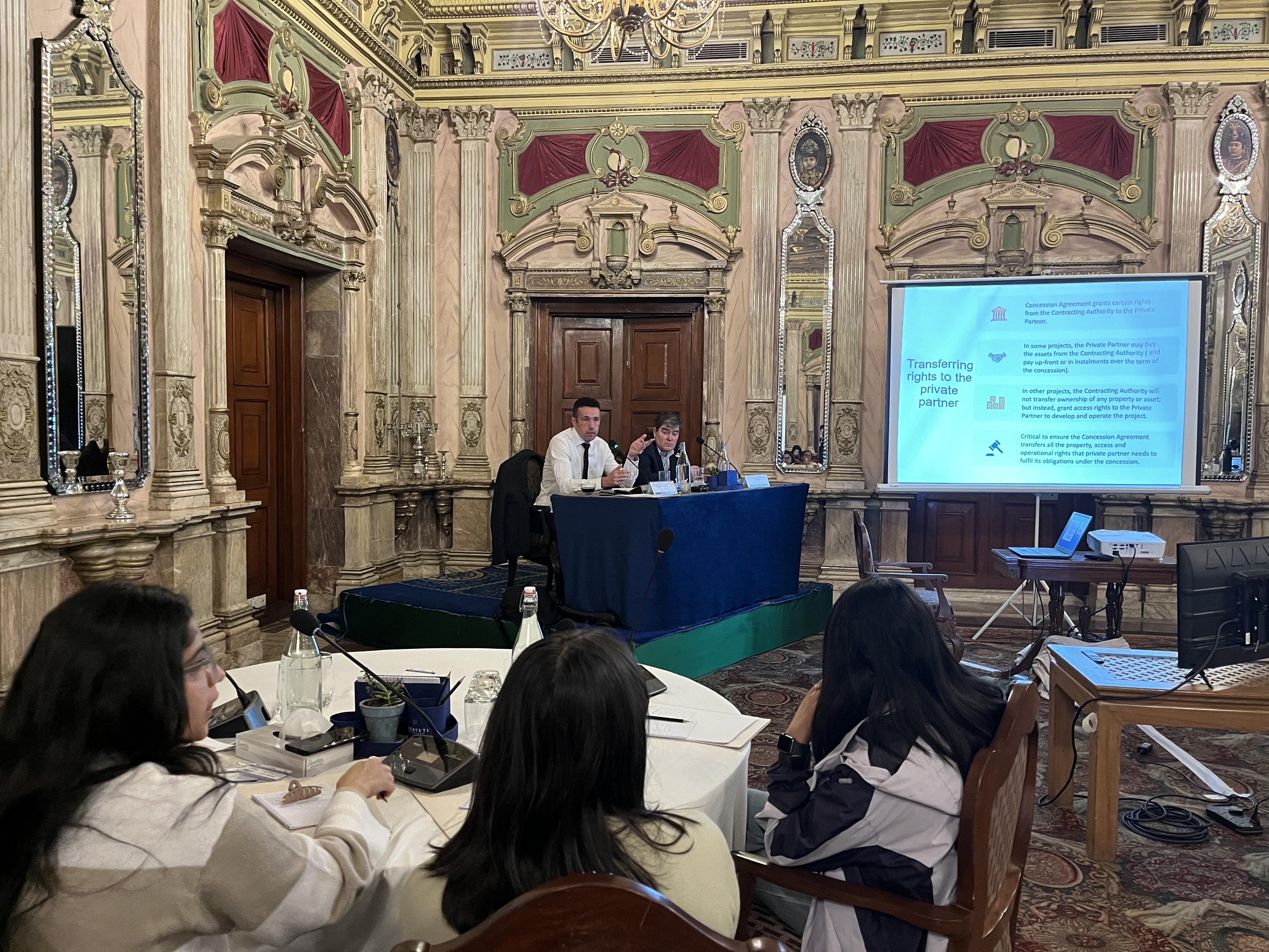 Presenters explain powerpoint slides while participants watch