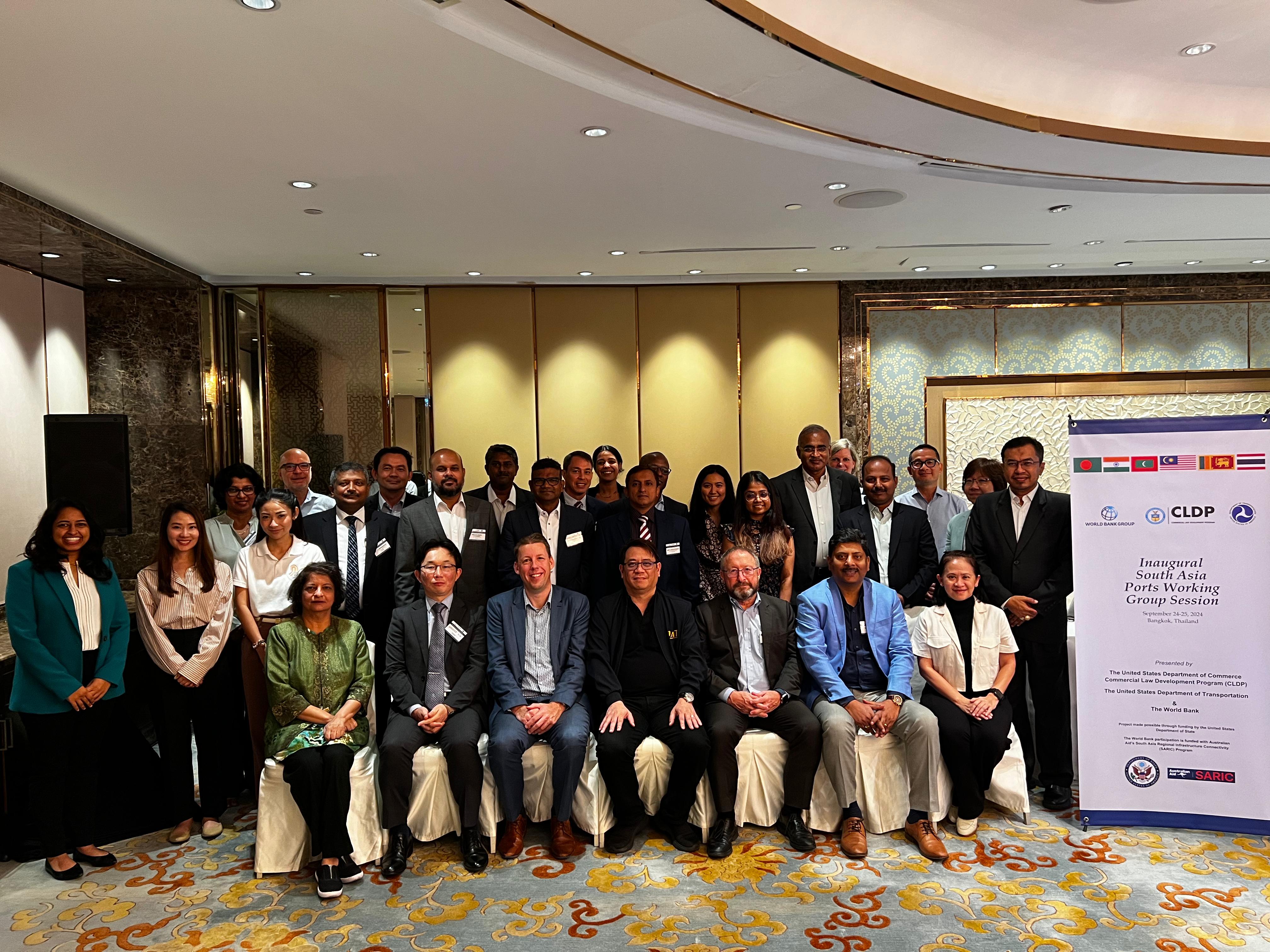 Group photo of participants from South Asia Ports CEO Working Group. People are sitting and standing next to a banner of the program.