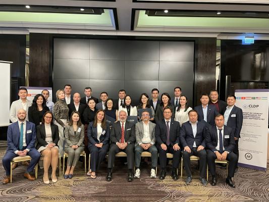 Group photo of participants of the Central Asia Regional PPP Information Exchange Workshop. On the right hand side is a banner with the title of the workshop.
