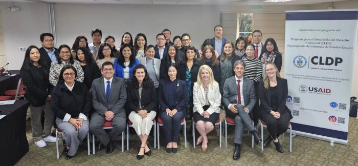 Group of people standing and smiling in two rows.
